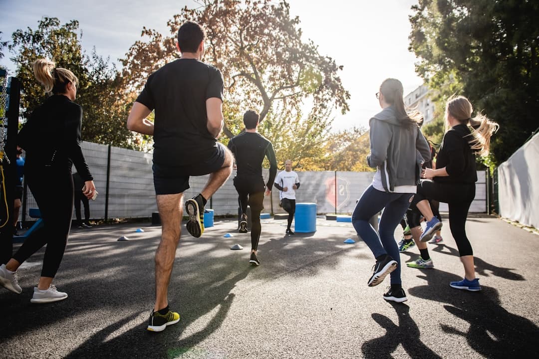 Groupe en pleine séance de HIIT guidé par un coach, dans une ambiance dynamique et motivante